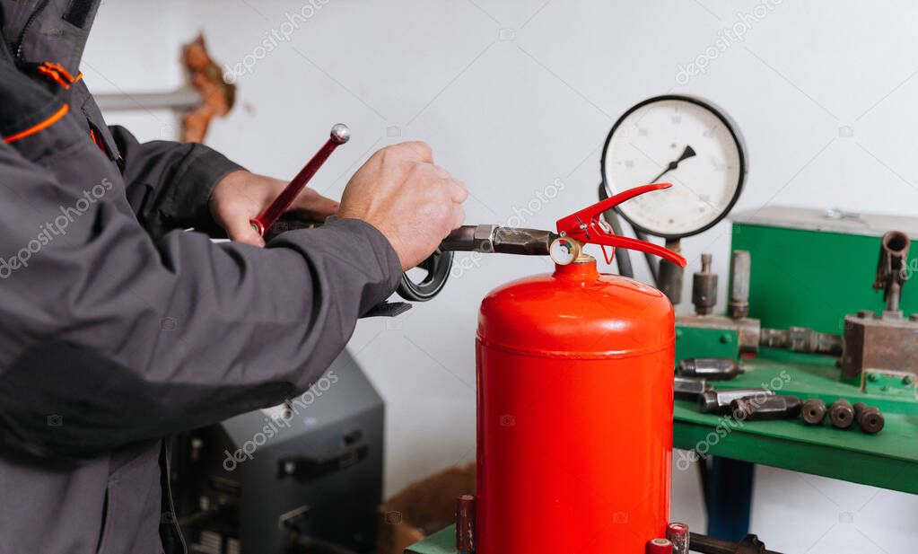Técnico recargando un extintor en taller